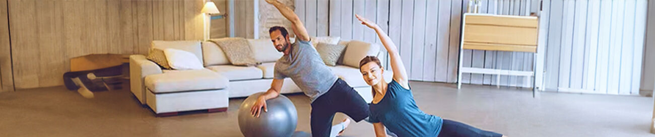Man and woman exercising with an exercise ball
